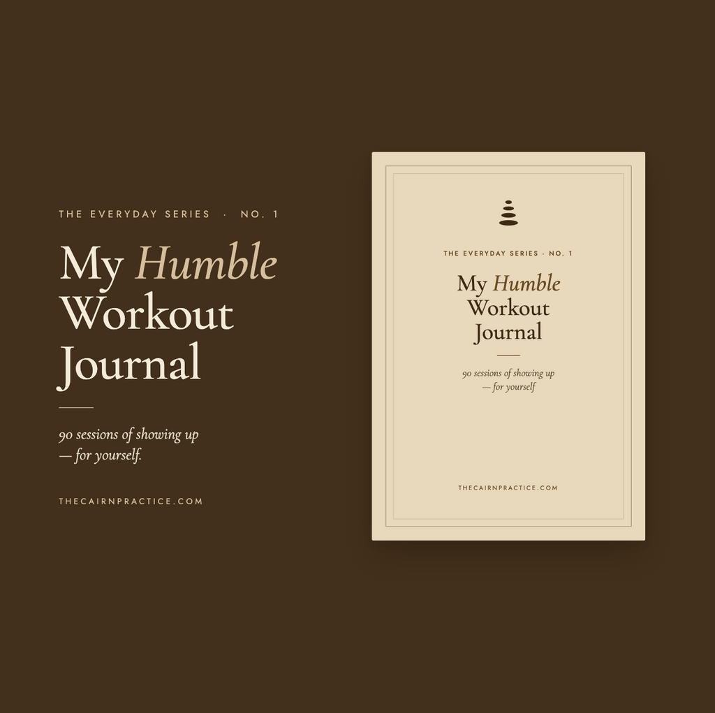 My Humble Workout Journal by The Cairn Practice — dark brown cover with a cairn stack mark, marked The Everyday Series No. 1, with the tagline "90 sessions of showing up — for yourself."
